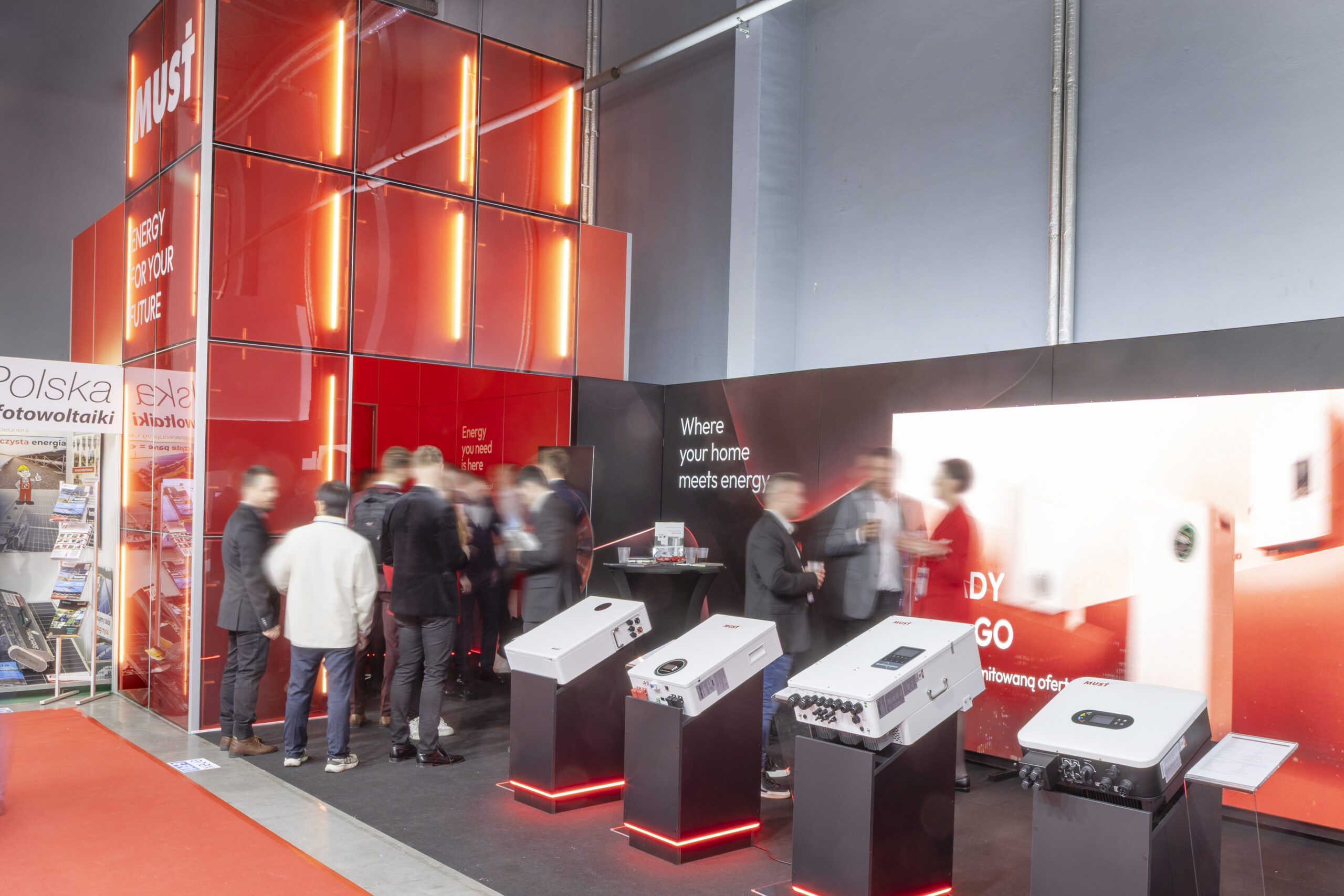Stoisko targowe w stylu modern - zabudowa Must Energy Polska panelami transparentnymi oraz nowoczesnym oświetleniem
