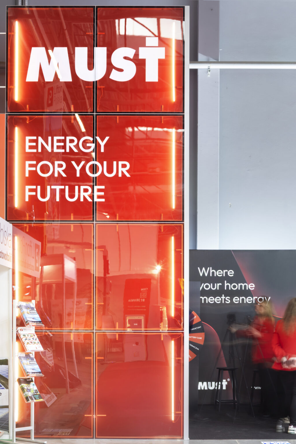 Stoisko targowe z transparentnymi panelami oraz oświetleniem linowym - zabudowa marki Must Energy Polska