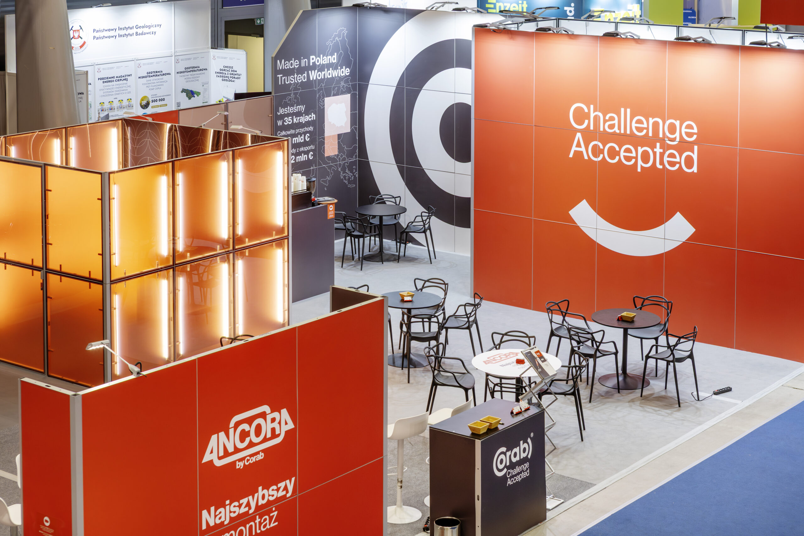 Zabudowa targowa marki Corab - stoisko w kolorystyce soczystej pomarańczy z nowoczesnym oświetleniem liniowym