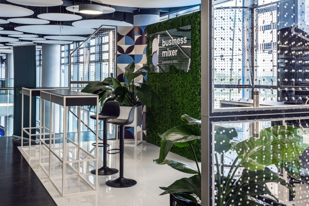 Stoisko targowe na konferencji Business Mixer - aranżacja z konsolami i hokerami